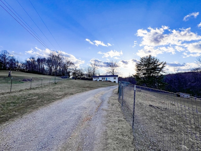 view of road featuring driveway, a gated entry, and a rural view