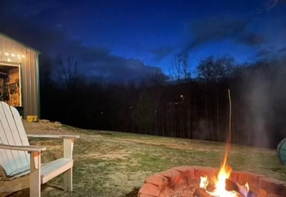 yard at night featuring an outdoor fire pit