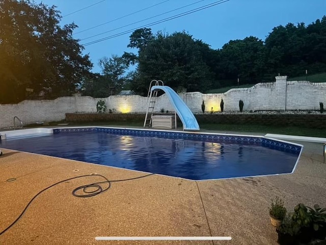 view of swimming pool with a fenced in pool, a patio, a fenced backyard, a water slide, and a diving board