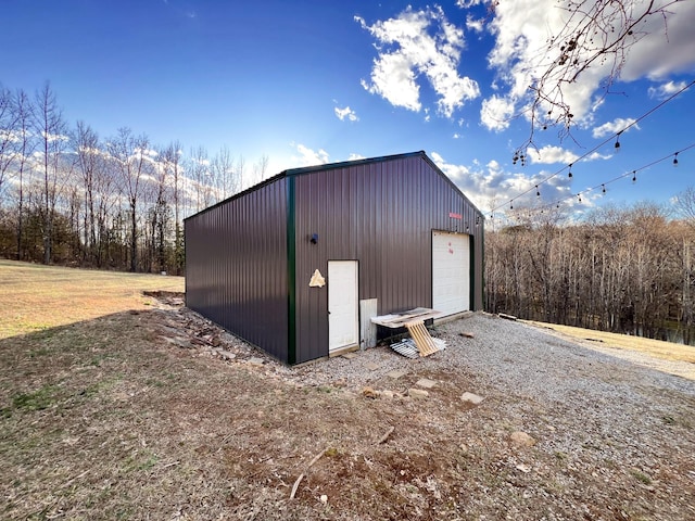 view of outdoor structure featuring an outbuilding and gravel driveway