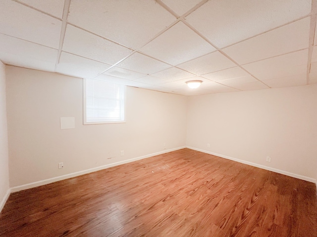 unfurnished room featuring a paneled ceiling, light wood-style floors, and baseboards