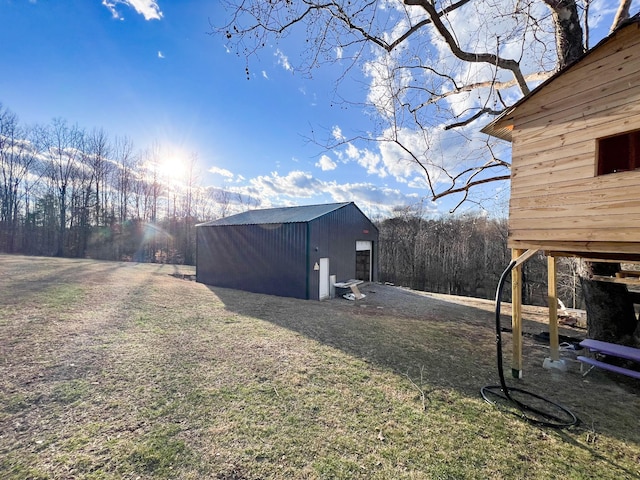 view of yard with a garage and an outbuilding