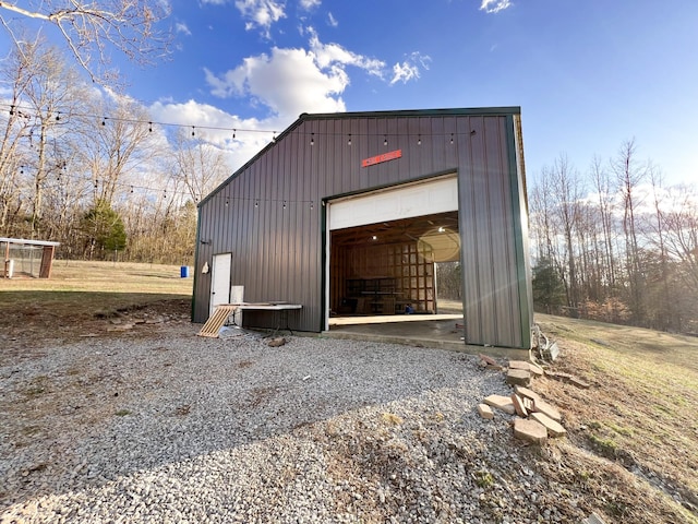 view of outdoor structure featuring gravel driveway and an outbuilding