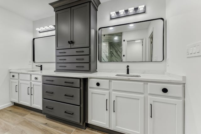 bathroom with baseboards, a shower stall, vanity, and wood finished floors