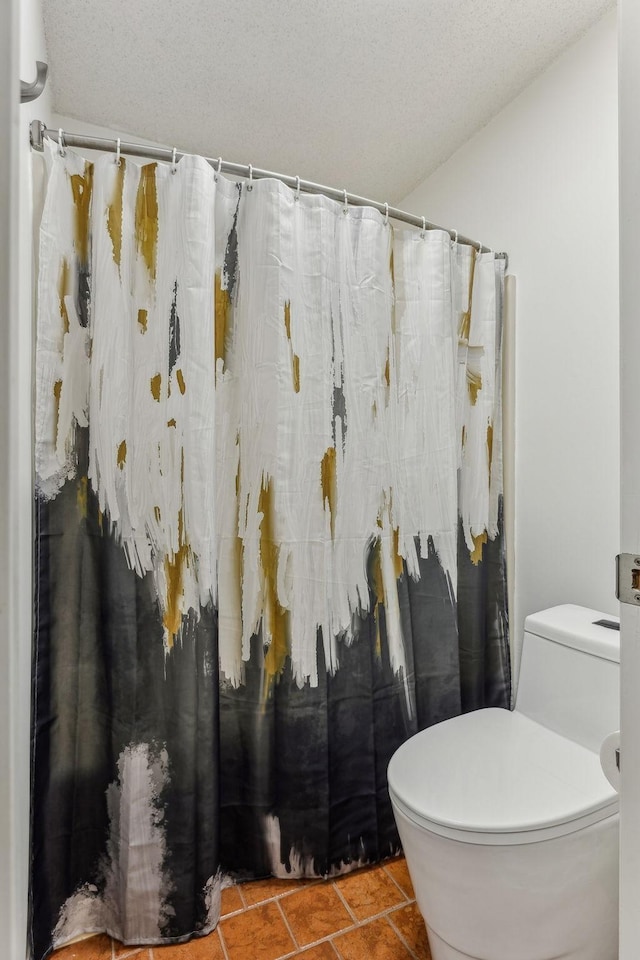 full bathroom with a textured ceiling, a shower with shower curtain, tile patterned flooring, and toilet