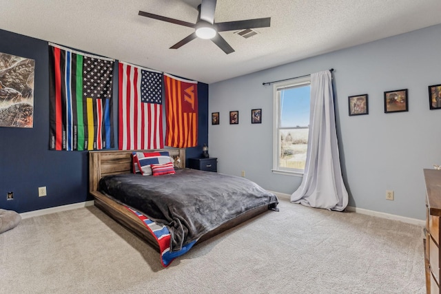 bedroom with carpet floors, baseboards, visible vents, and a textured ceiling