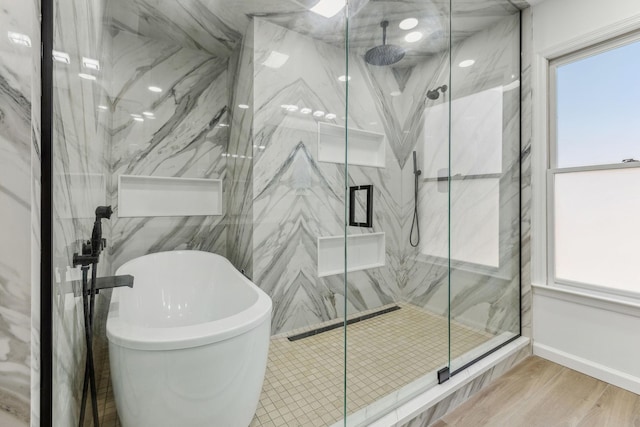 full bath with a freestanding tub, a marble finish shower, and wood finished floors