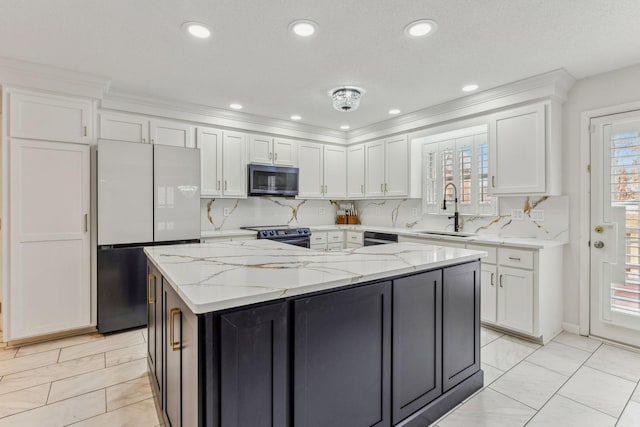 kitchen with a center island, backsplash, white cabinets, a sink, and black appliances