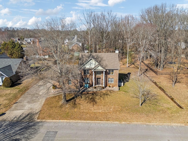 view of front of property with a front lawn, concrete driveway, and brick siding