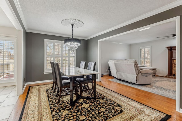 dining area with crown molding, light wood-style flooring, and a healthy amount of sunlight