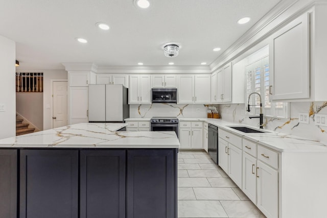 kitchen featuring stainless steel appliances, a sink, a center island, and white cabinets