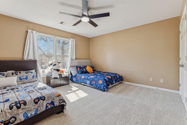 bedroom featuring a textured ceiling, carpet floors, a ceiling fan, visible vents, and baseboards