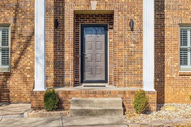 view of exterior entry with brick siding