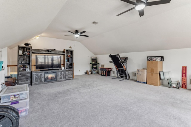 living room featuring ceiling fan, visible vents, vaulted ceiling, and carpet flooring