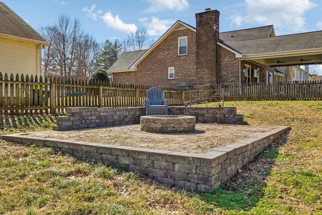 exterior space with an outdoor fire pit and fence