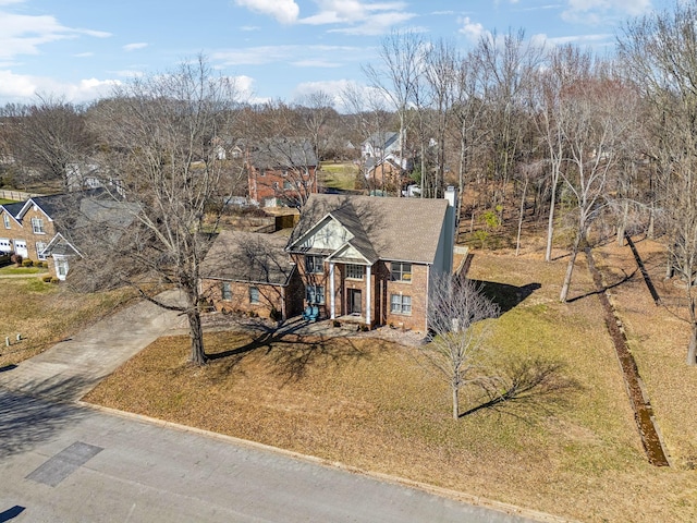 view of front of home featuring a front yard, concrete driveway, and a chimney