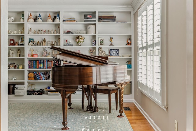 living area with baseboards, visible vents, and wood finished floors