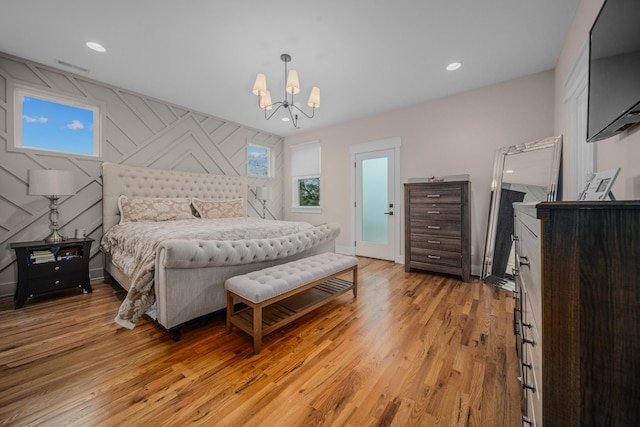 bedroom with baseboards, light wood finished floors, recessed lighting, and an inviting chandelier