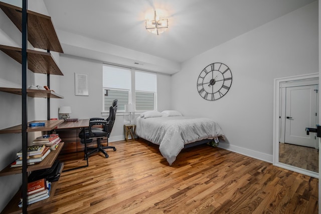 bedroom featuring wood finished floors, visible vents, and baseboards