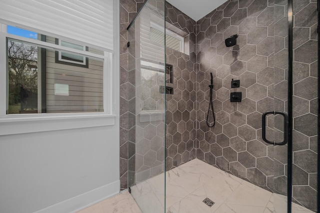 full bath featuring baseboards, marble finish floor, a shower stall, and a healthy amount of sunlight