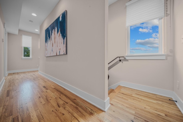 corridor with an upstairs landing, recessed lighting, baseboards, and wood finished floors