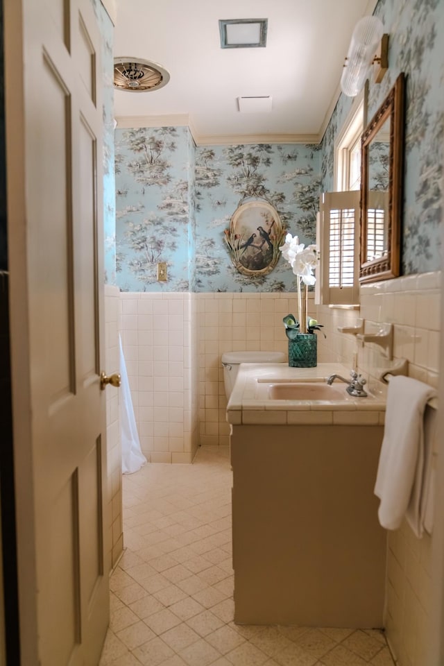 bathroom featuring a wainscoted wall, tile walls, vanity, and wallpapered walls