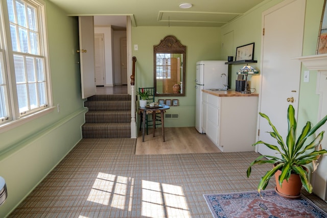 kitchen featuring light wood-style flooring, butcher block countertops, a sink, visible vents, and open shelves