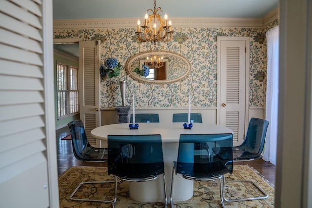 dining area featuring wood finished floors, a wainscoted wall, a notable chandelier, and wallpapered walls