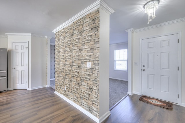 entrance foyer featuring baseboards, ornamental molding, a chandelier, and wood finished floors