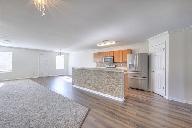 kitchen with dark wood finished floors, decorative backsplash, brown cabinets, stainless steel appliances, and light countertops