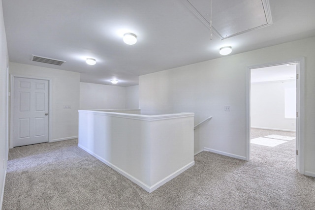 hall featuring visible vents, carpet floors, an upstairs landing, and attic access