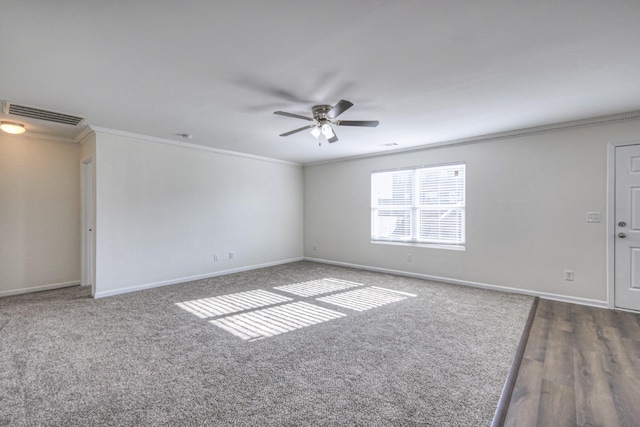 empty room with baseboards, a ceiling fan, visible vents, and crown molding