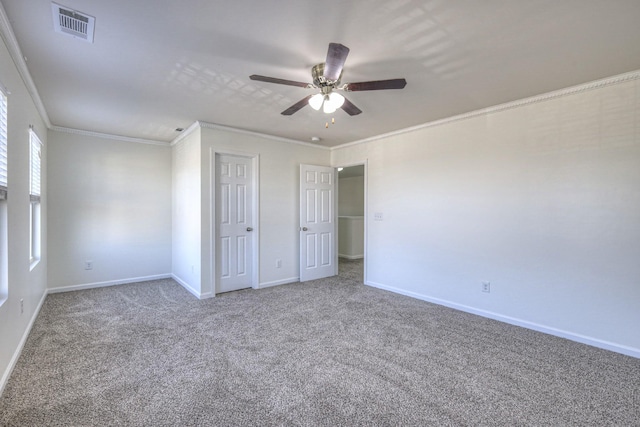 unfurnished bedroom with baseboards, visible vents, ceiling fan, ornamental molding, and carpet flooring