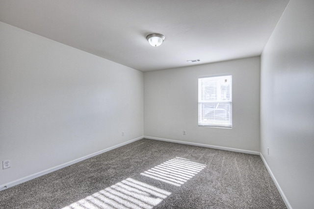 empty room with carpet floors, visible vents, and baseboards