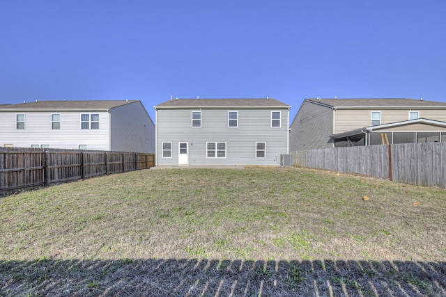 back of property with a yard, a fenced backyard, and central air condition unit