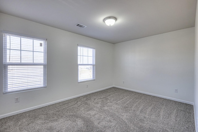 carpeted spare room with baseboards and visible vents