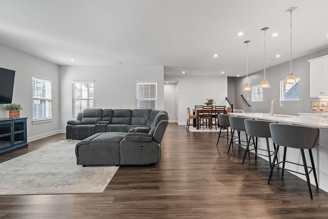 living area with dark wood-type flooring, recessed lighting, and baseboards