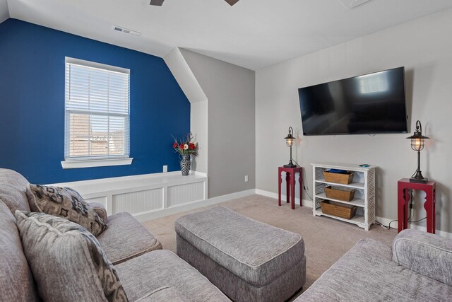carpeted living room featuring lofted ceiling, baseboards, visible vents, and a ceiling fan