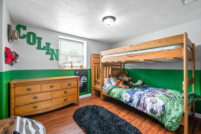 bedroom featuring a textured ceiling, visible vents, and wood finished floors