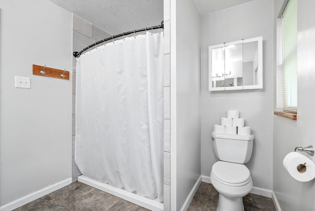 full bathroom featuring toilet, baseboards, and a shower with shower curtain