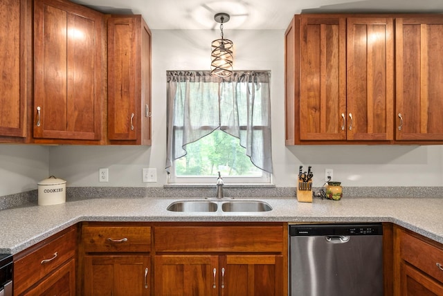 kitchen with brown cabinetry, light countertops, stainless steel dishwasher, pendant lighting, and a sink