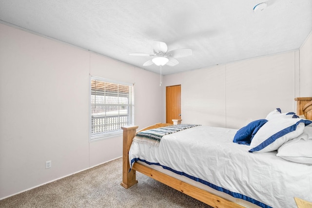 carpeted bedroom featuring ceiling fan and a textured ceiling