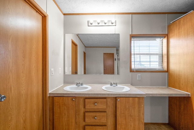 full bathroom featuring a textured ceiling, double vanity, and a sink