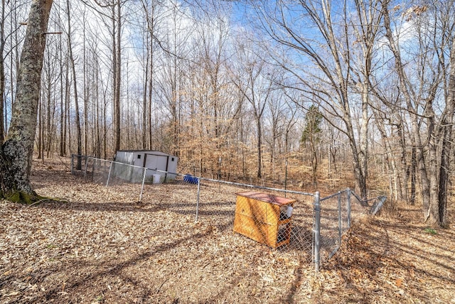 view of yard featuring an outbuilding, a shed, and fence