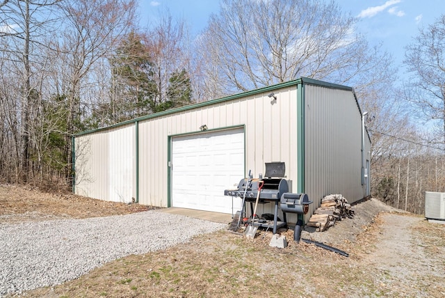 view of outdoor structure featuring an outbuilding, cooling unit, and driveway