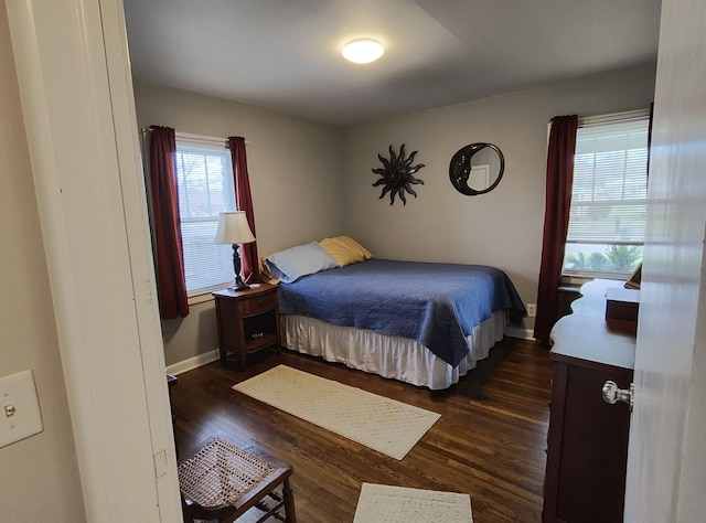 bedroom with dark wood finished floors and baseboards