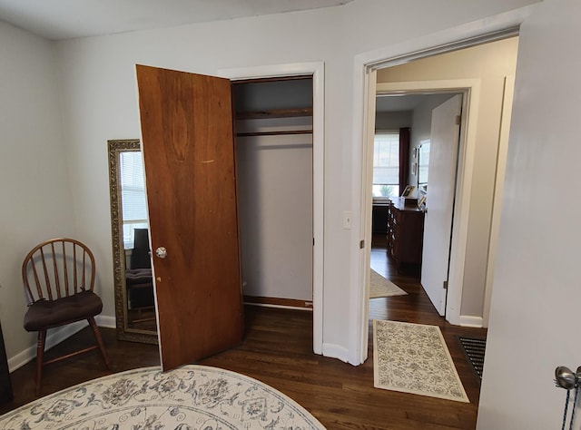 bedroom featuring dark wood-style floors, baseboards, and a closet