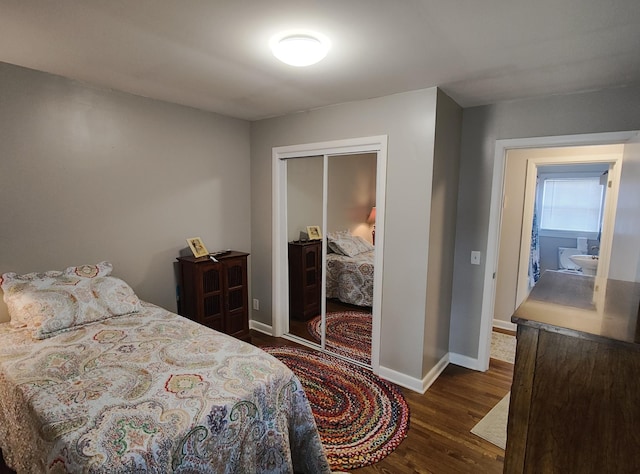 bedroom featuring a closet, baseboards, and dark wood-type flooring