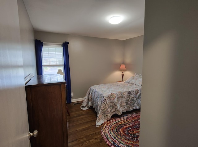 bedroom with dark wood-type flooring, visible vents, and baseboards