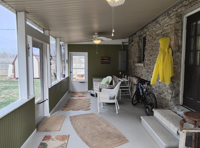 sunroom featuring electric panel and a ceiling fan